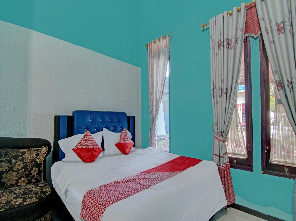 ein Schlafzimmer mit einem Bett mit roten Kissen darauf in der Unterkunft OYO 92872 Swakarya Guest House in Parit