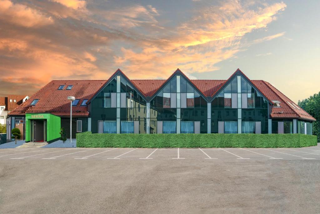 a building with a parking lot in front of it at SEKRA Stadthotel 