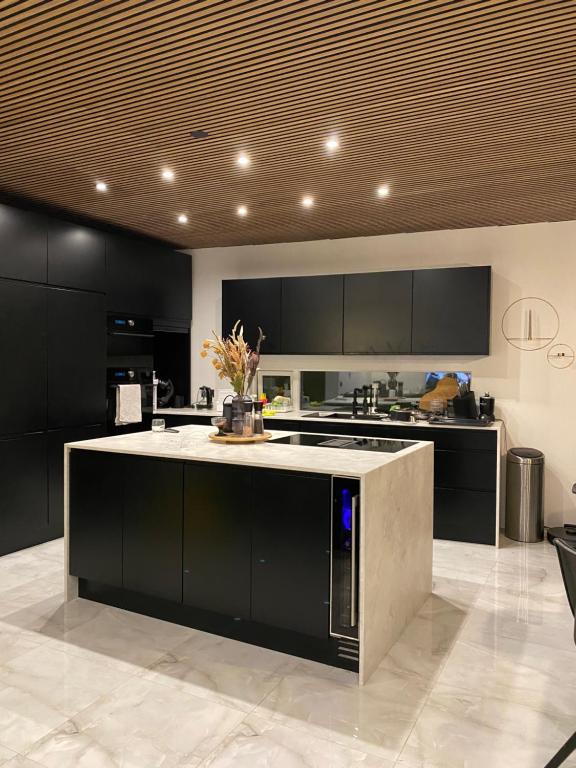 a kitchen with black cabinets and a white counter top at Luxury villa with gym and sauna in Reykjavík