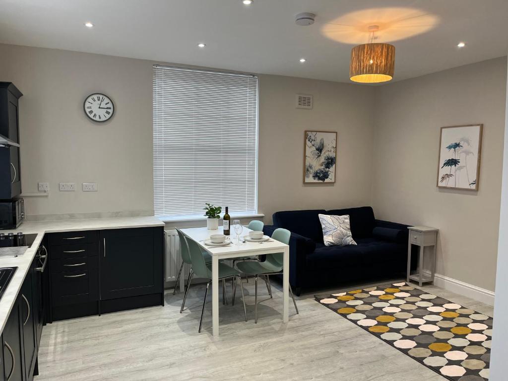 a kitchen and living room with a table and a couch at Charming 1 bed Georgian Apartment in Chester