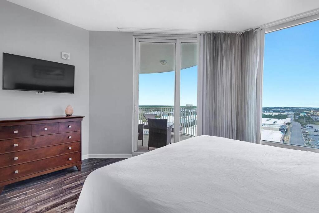ein Schlafzimmer mit einem Bett und einer Kommode mit einem Fernseher in der Unterkunft Beautiful Junior near the beach Palms Resort in Destin in Destin