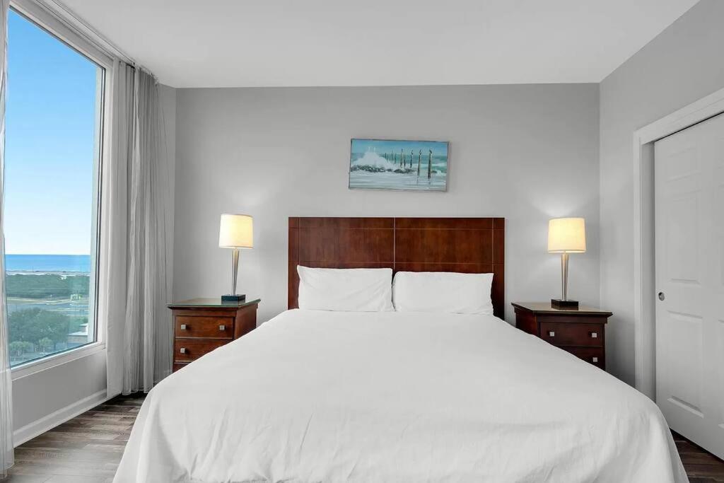 ein Schlafzimmer mit einem großen weißen Bett und einem großen Fenster in der Unterkunft Beautiful Junior near the beach Palms Resort in Destin in Destin