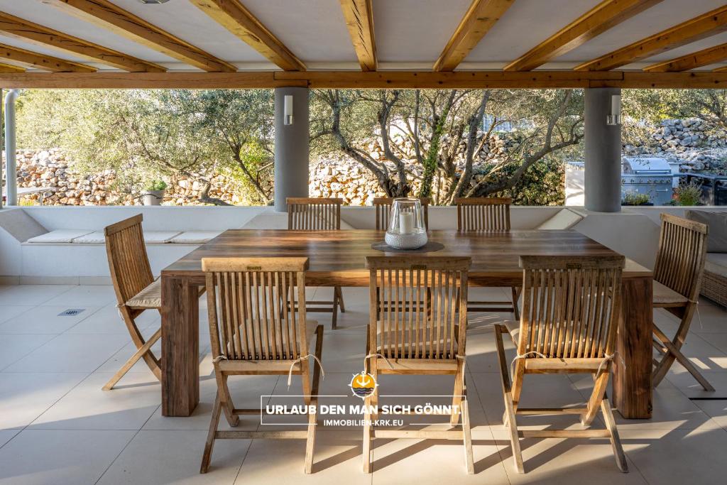 drewniany stół i krzesła na patio w obiekcie Villa 5 elements w mieście Gostinjac