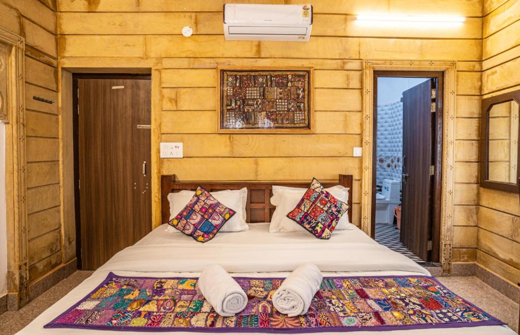 um quarto com uma cama com almofadas em Hotel Relax Inn Jaisalmer em Jaisalmer
