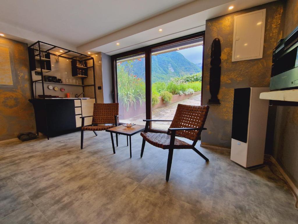 a living room with a table and chairs and a view at Apartments & wellness Kal Koritnica in Bovec