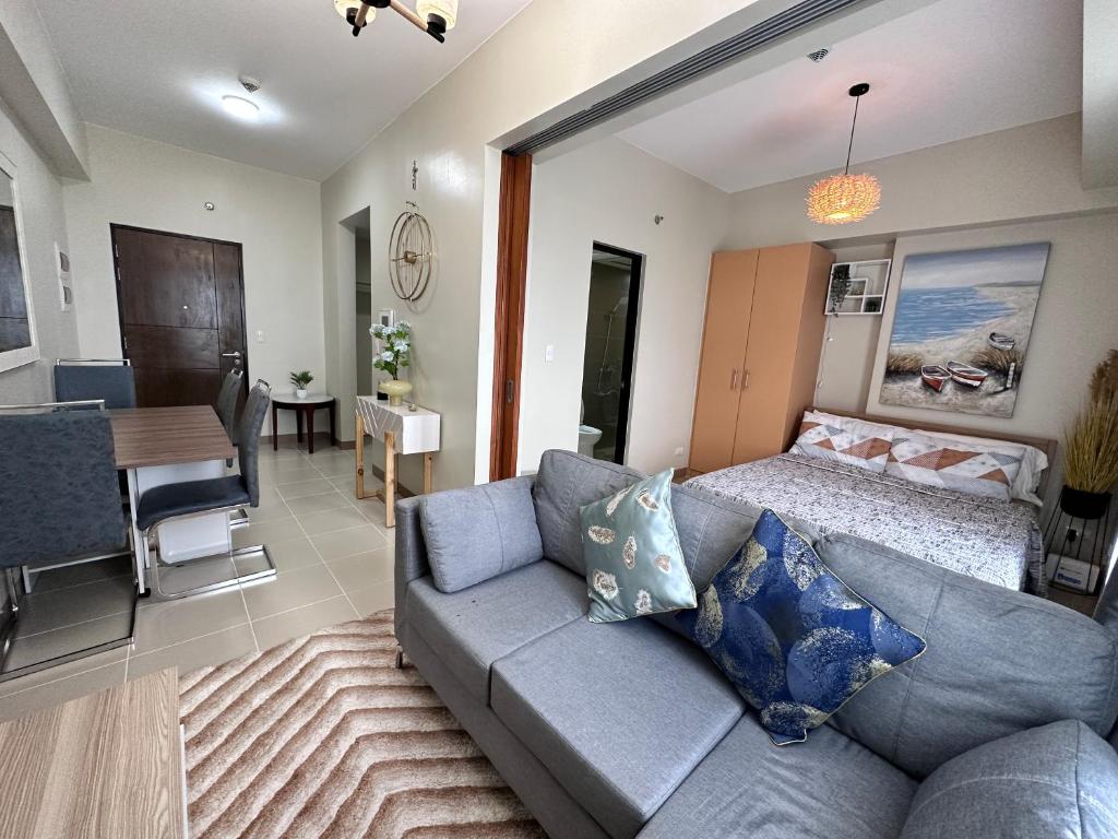 uma sala de estar com um sofá e uma sala de jantar em THE PALLADIUM- Serene em Iloilo