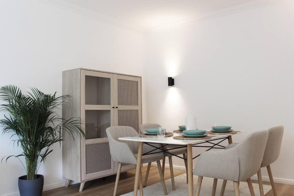 a dining room with a table and chairs and a cabinet at Cozy, Quiet Munich City Apartment in Munich