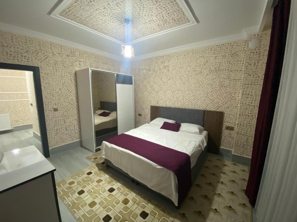 a bedroom with a large bed and a mirror at EGE SUİT OTEL in Amasra