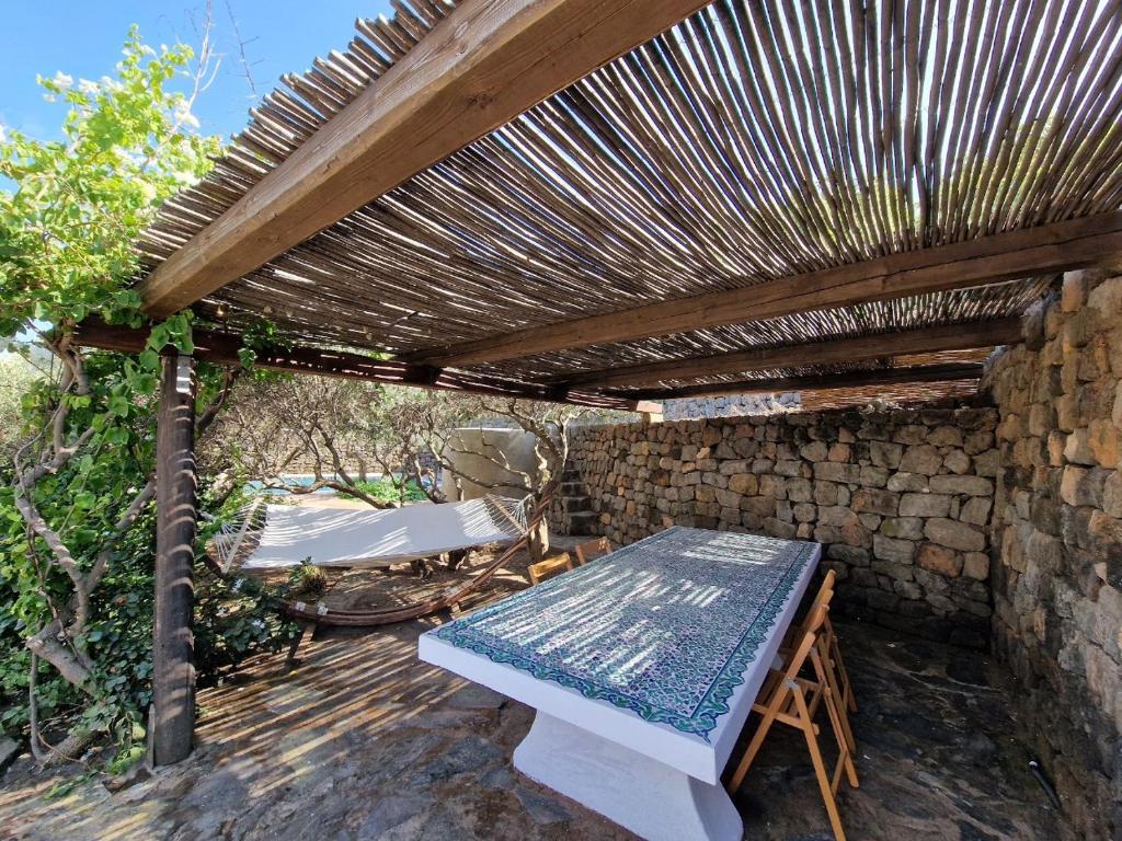 pergolato in legno con panca e tavolo di Il Paradiso nascosto a Pantelleria
