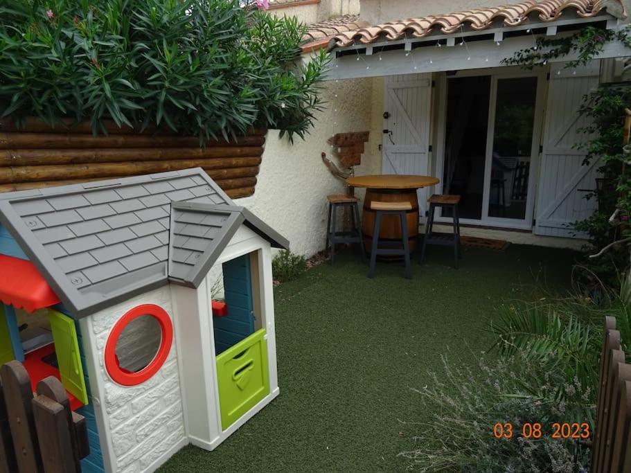 una casa de perros de juguete sentada junto a una mesa en Baby Home cosy à 1km de la mer, en Saint-Cyprien