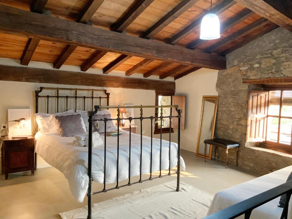 een slaapkamer met een bed in een kamer met houten plafonds bij La Grulla Gris in Perales del Puerto