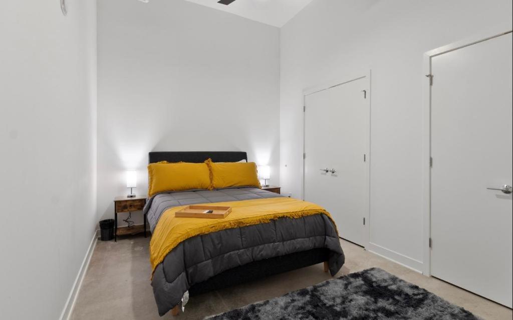 um quarto com uma cama com um cobertor amarelo e almofadas amarelas em Downtown Near Busch Stadium/Convention Center em Saint Louis