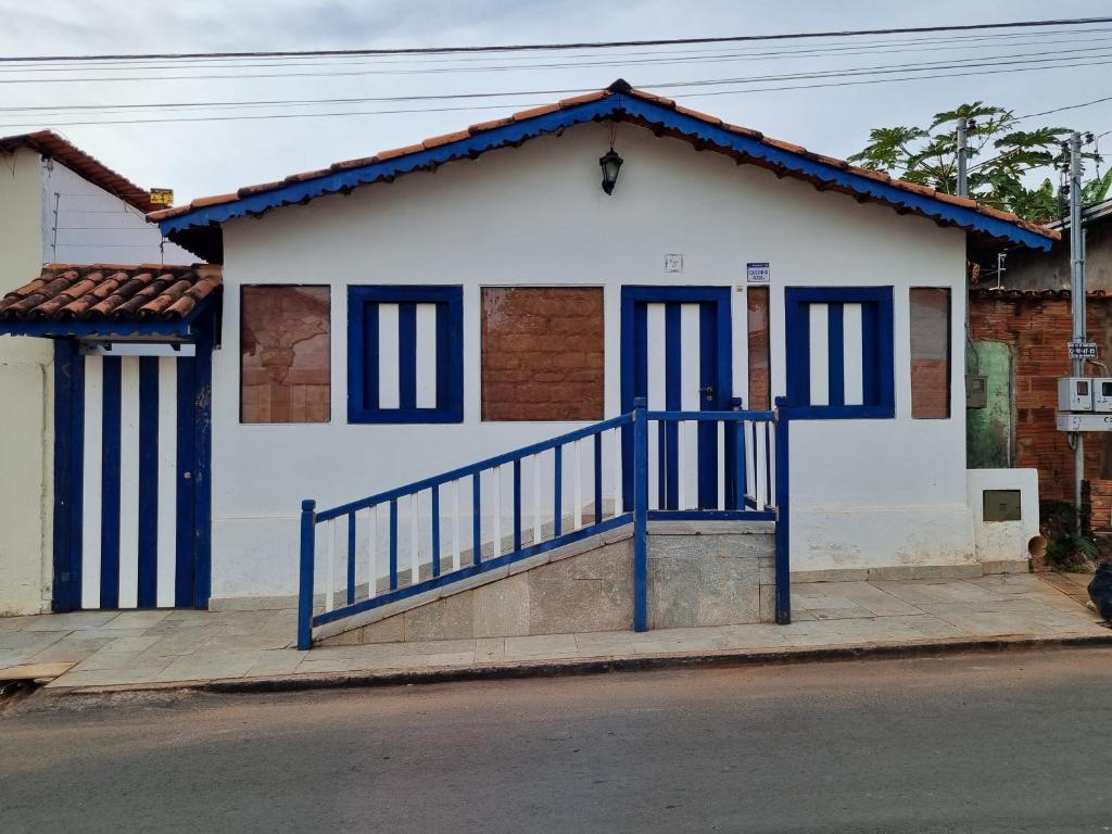 Casa blanca y azul con barandilla azul en CASINHA AZUL/PIRINOPOLIS en Pirenópolis