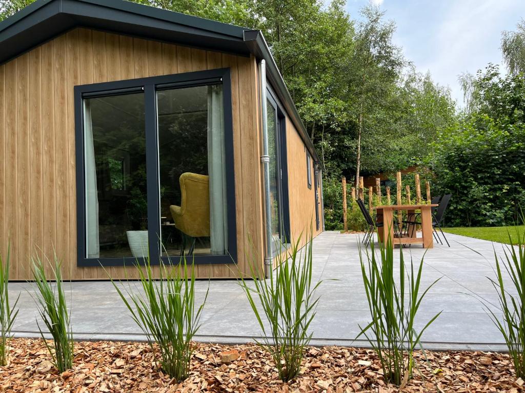 ein winziges Haus mit einem großen Fenster in einem Garten in der Unterkunft Landzicht Natuur Rust en Ruimte in Oosterwolde