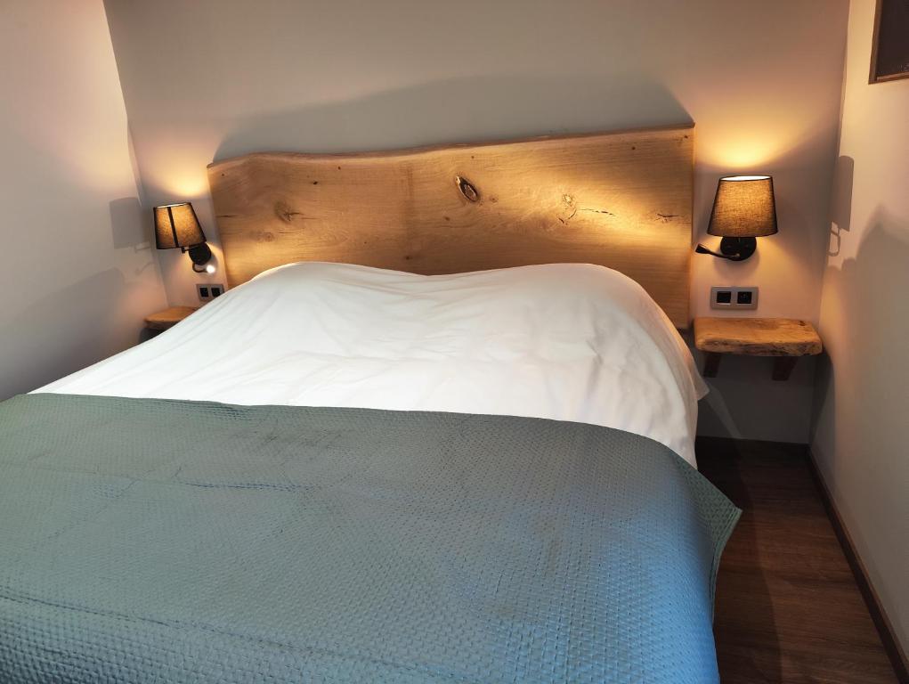 een slaapkamer met een groot wit bed met 2 lampen bij Le Saint Michel in Rochefort