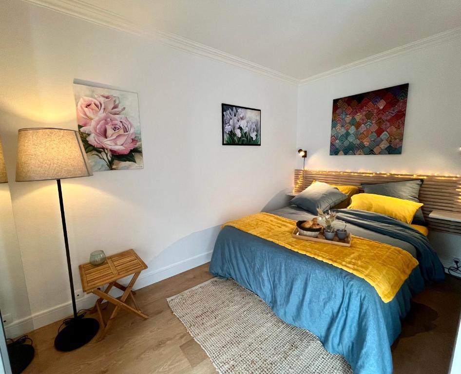 1 dormitorio con 1 cama con colcha azul y amarilla en Cœur de Concarneau, en Concarneau