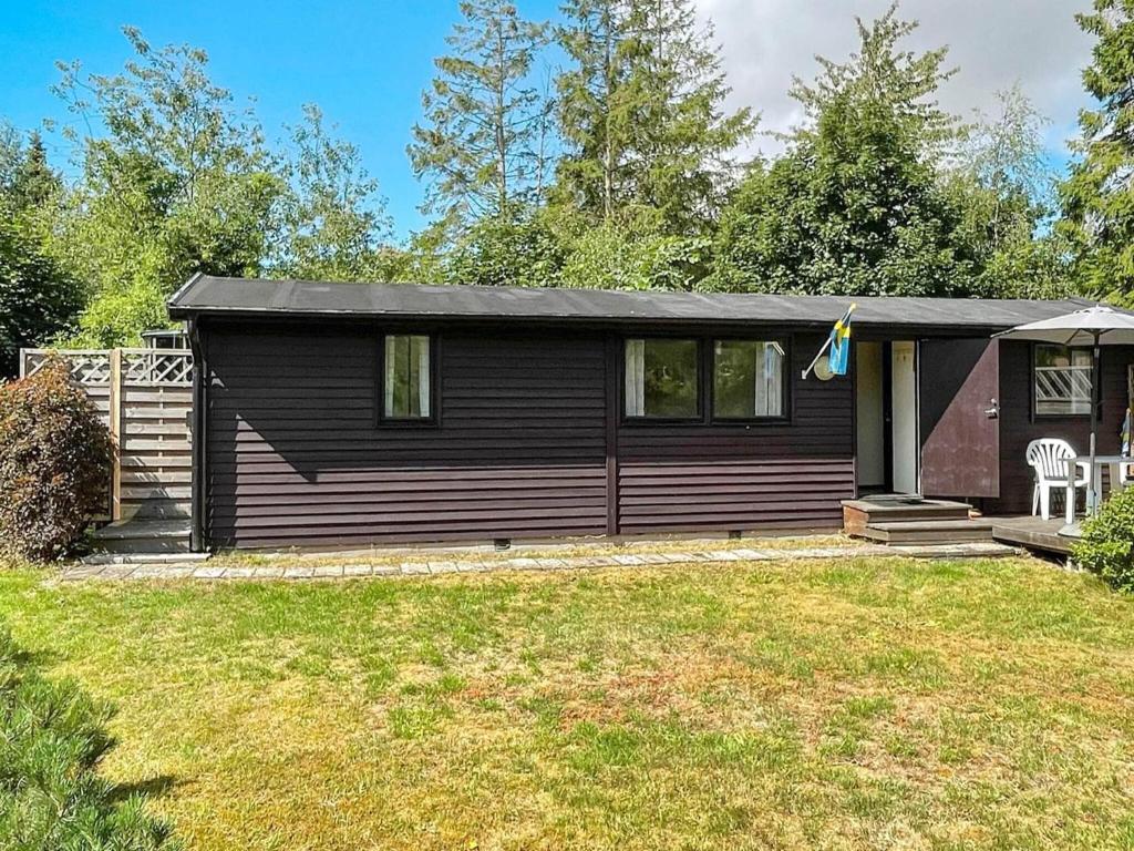 a small black house with a yard at 4 person holiday home in Beddingestrand-By Traum in Beddinge Strand