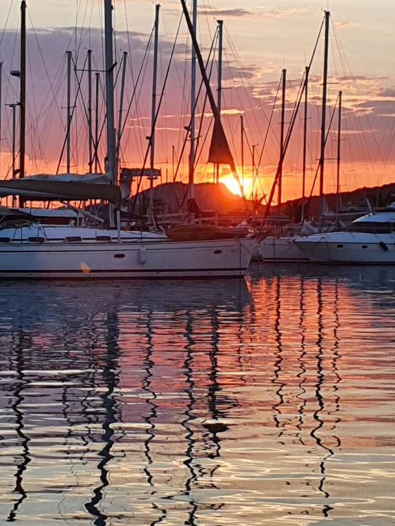 un groupe de bateaux amarrés dans l'eau au coucher du soleil dans l'établissement Porquerolles - Nuit insolite à bord du Défi Fou, à Porquerolles