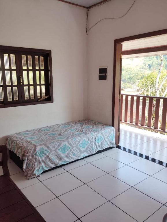 um quarto com uma cama num quarto com uma janela em Refugio Das Pedras em Paraty