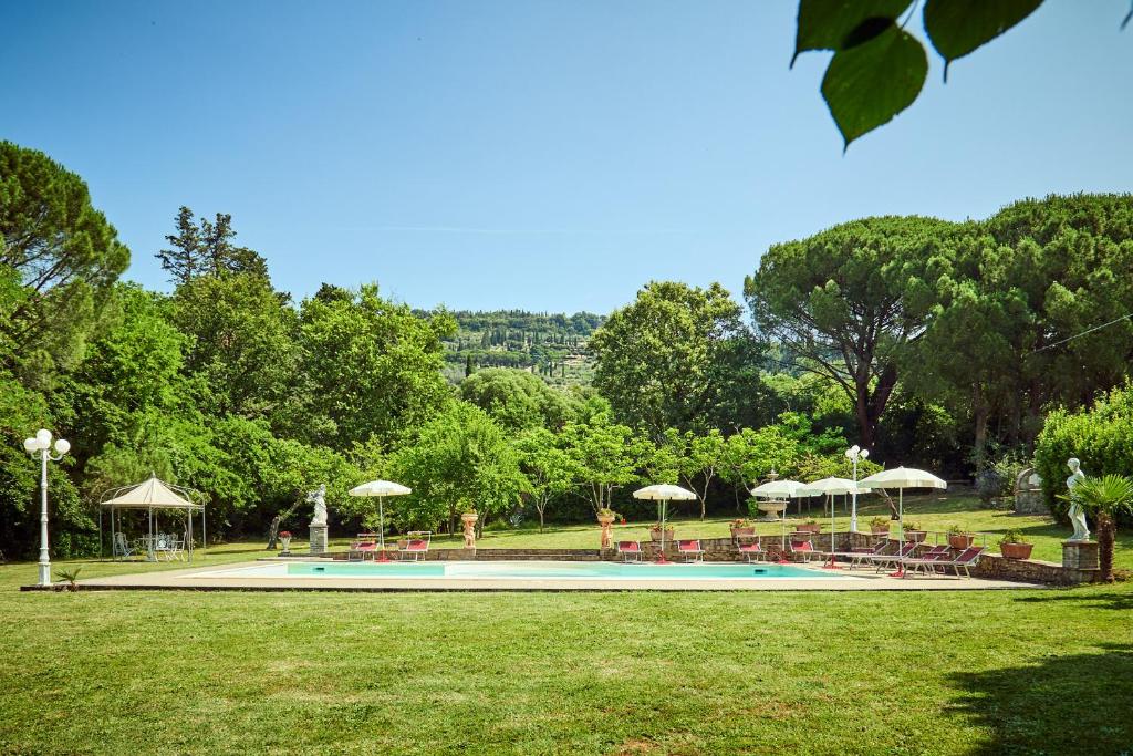 a swimming pool with tables and chairs and umbrellas at Villa Augusto in Cortona