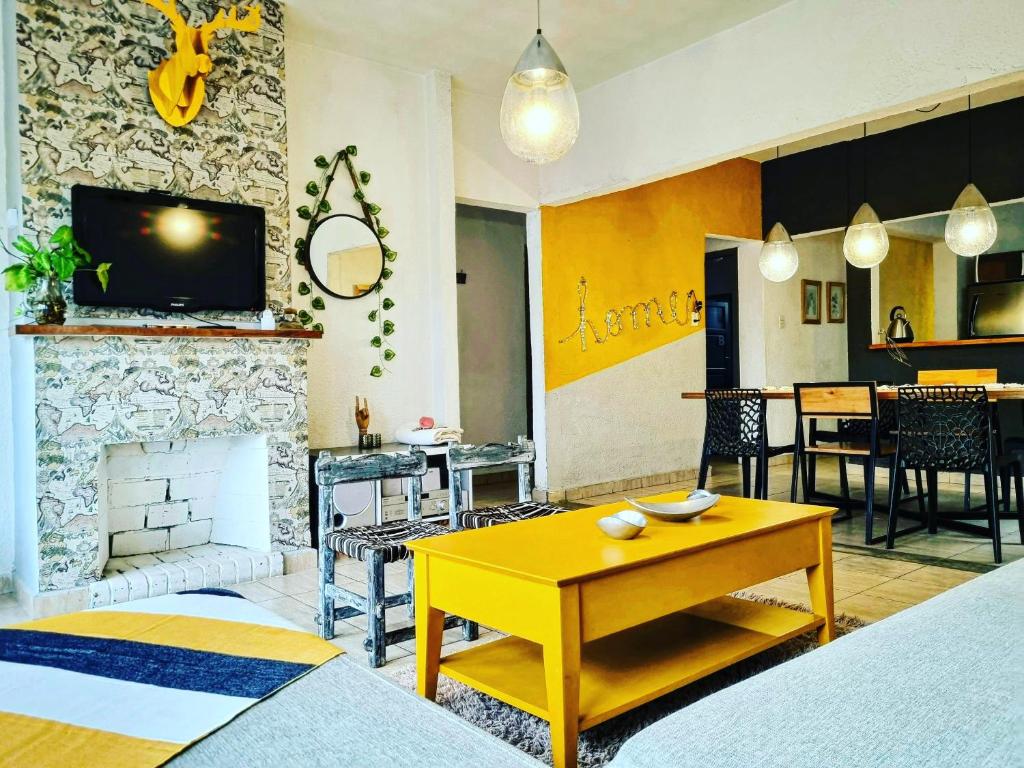 sala de estar con mesa amarilla y chimenea en DESIGN HOME CERRO 8Pax Cerro de Las Rosas en Córdoba