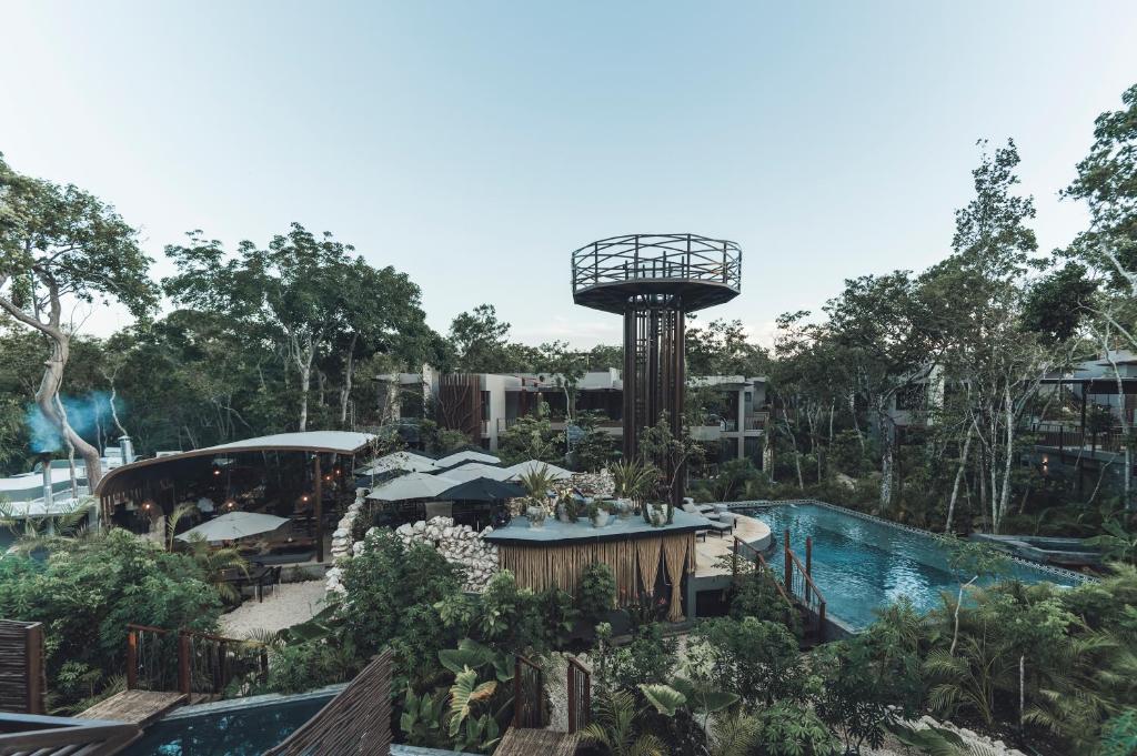 a resort with a swimming pool and a tower at Siwa Tulum in Tulum