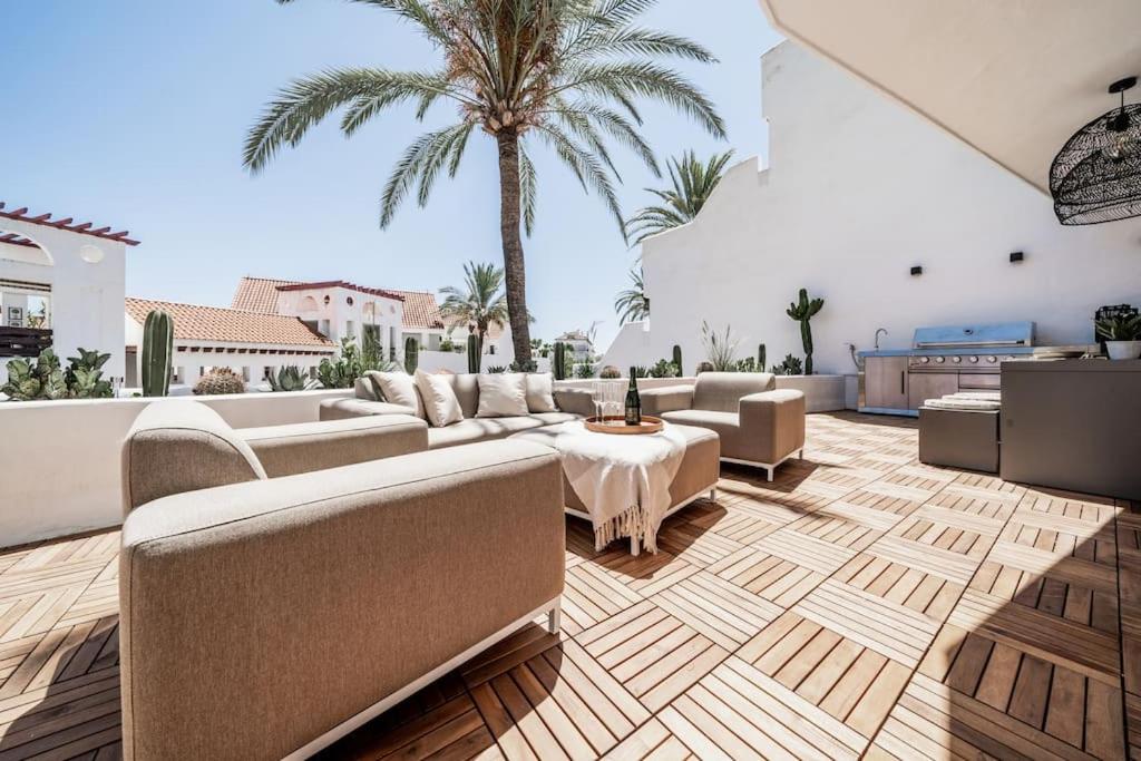 a living room with couches and a table and palm trees at Super Stylish Apartment in Fantastic Location in Marbella