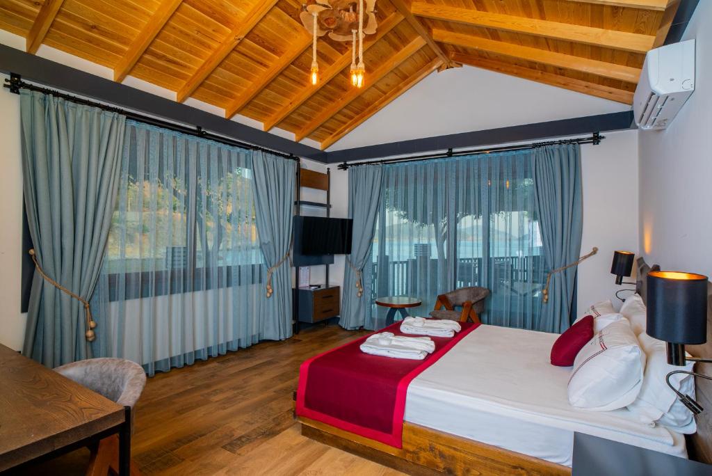 a bedroom with a bed and a desk and windows at Club Porto Amore Hotel Adults Only in Alanya