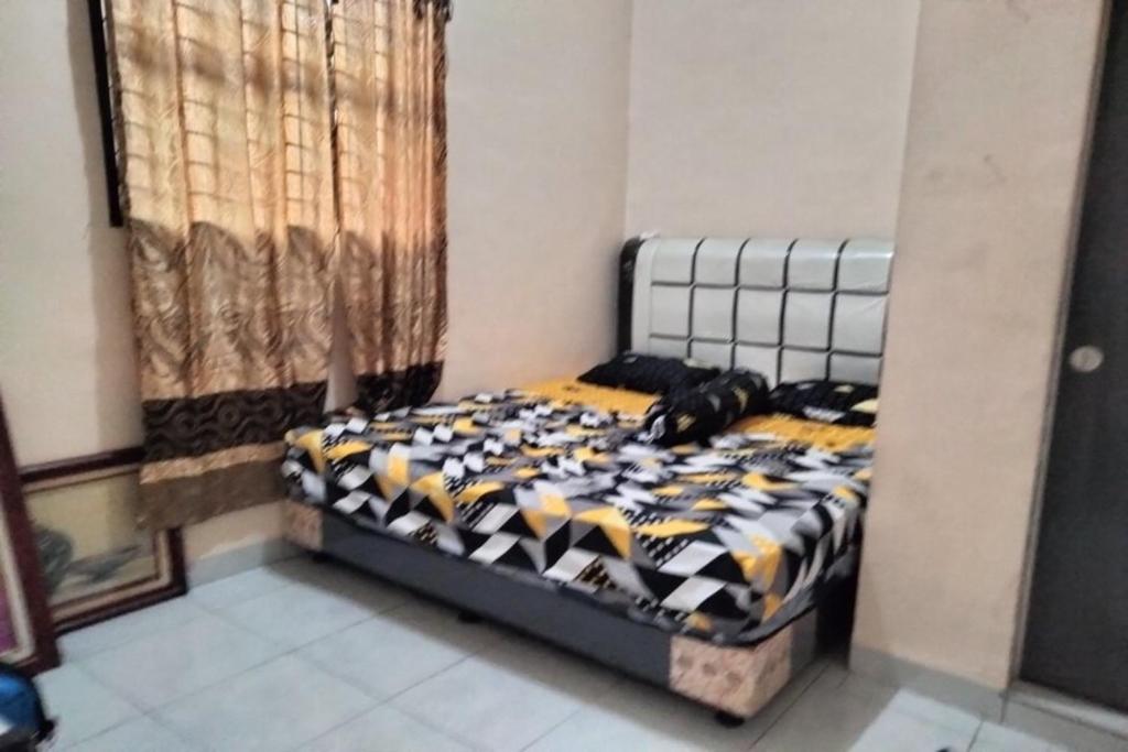 Schlafzimmer mit einem Bett mit einer schwarzen und weißen Bettdecke in der Unterkunft OYO 92881 Nany Ayahanda Syariah in Medan
