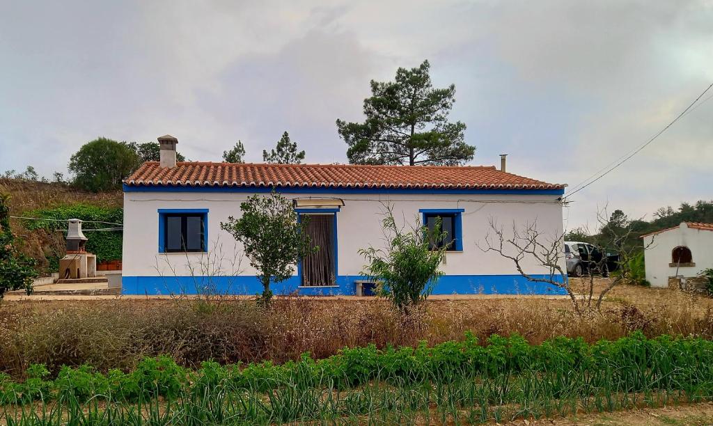 Una pequeña casa blanca con pintura azul. en Charme Rústico, en Aljezur