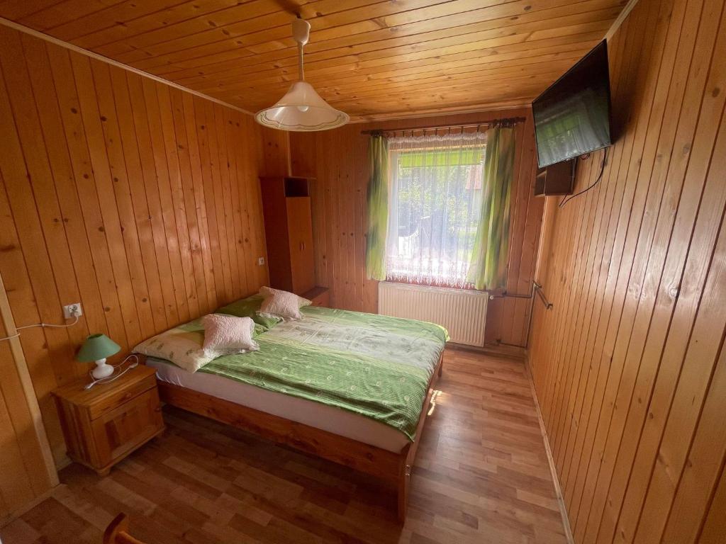 a bedroom with a bed in a wooden room at Przystanek Wetlina in Wetlina