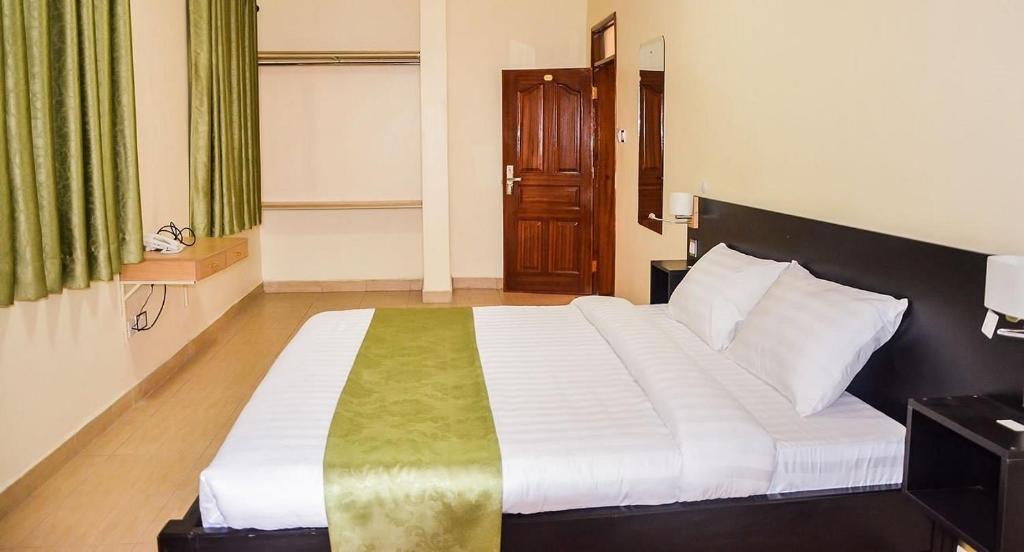 Postel nebo postele na pokoji v ubytování Ubuntu Palace Hotel Kampala