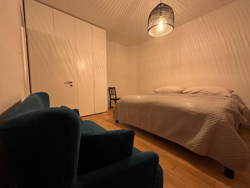 ein Schlafzimmer mit einem Bett und einem Stuhl in der Unterkunft Grand Appartement Lumineux - STELLA Loft - À deux pas du Lac Léman in Veytaux