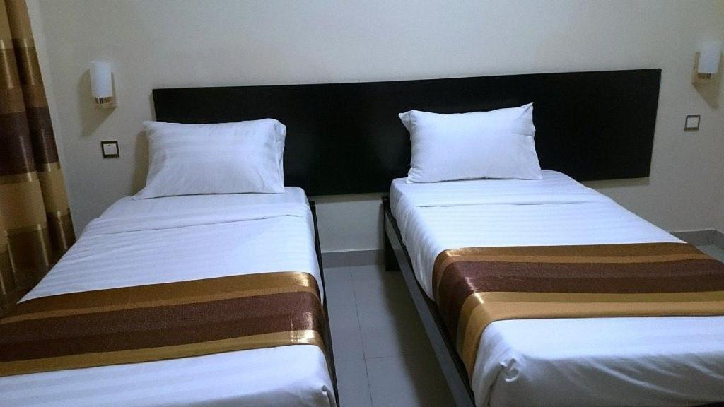 Postel nebo postele na pokoji v ubytování Ubuntu Palace Hotel Kampala
