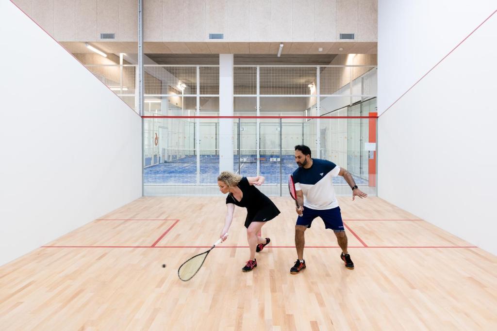 a man and a woman playing a game of tennis at UCPA SPORT STATION HOSTEL PARIS in Paris