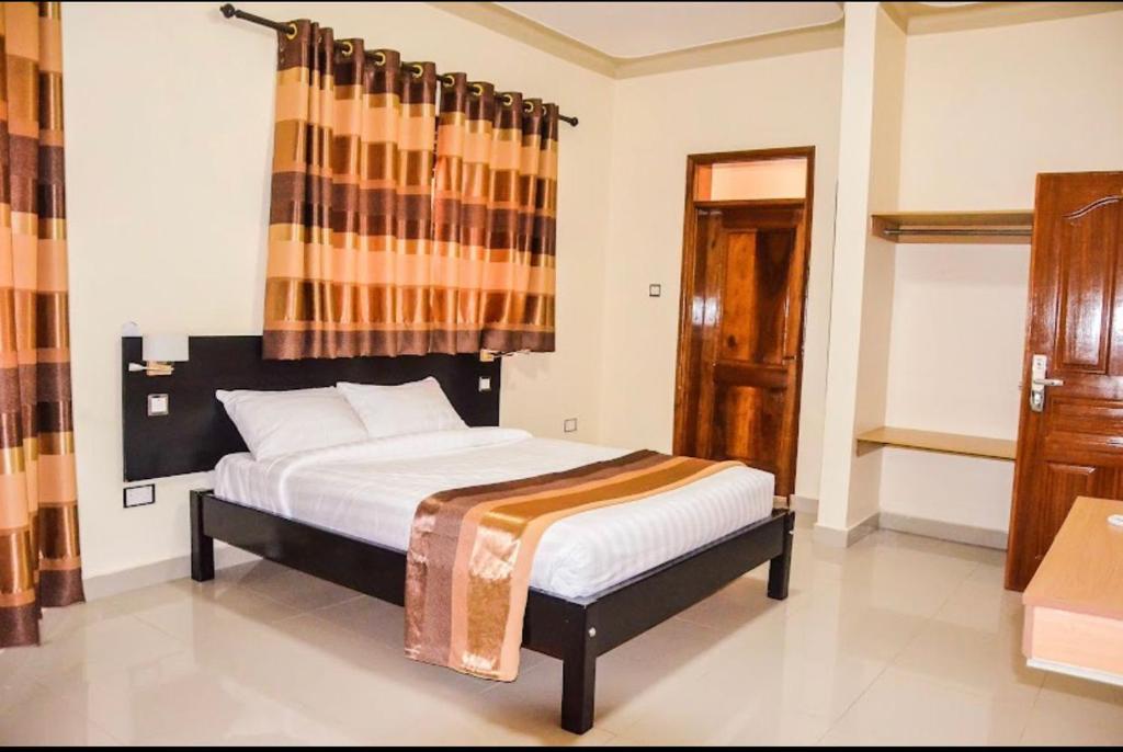 Postel nebo postele na pokoji v ubytování Ubuntu Palace Hotel Kampala