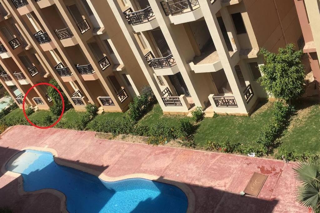 a building with a swimming pool in front of a building at Summer vacation flat in Dawwār Ruḩayyim