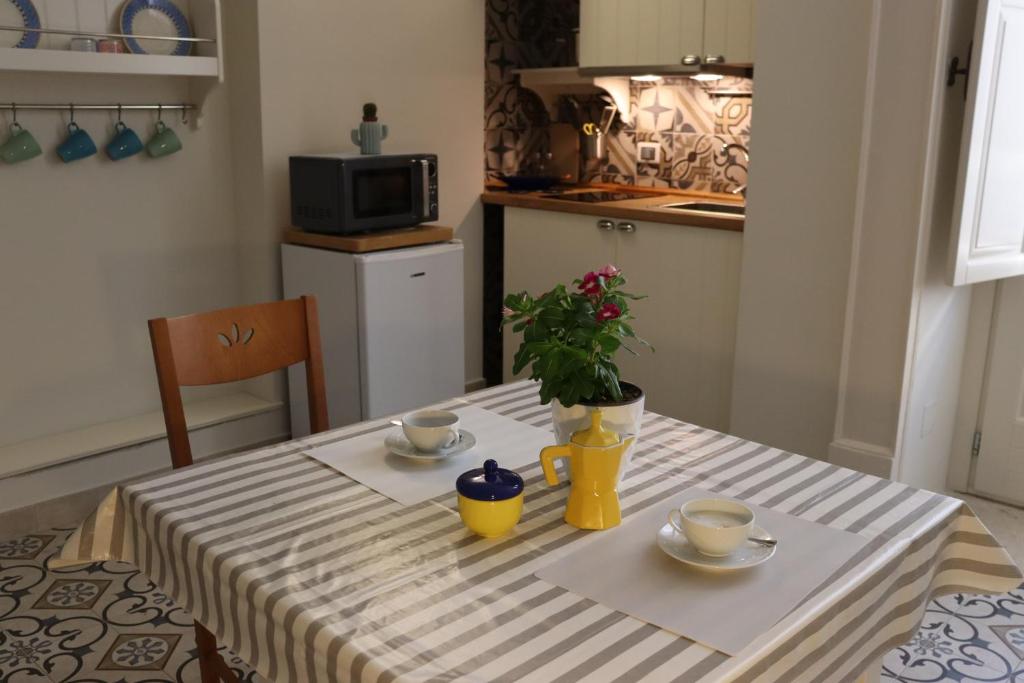 una mesa con dos tazas y una planta en ella en Casa Santa Caterina en Massafra