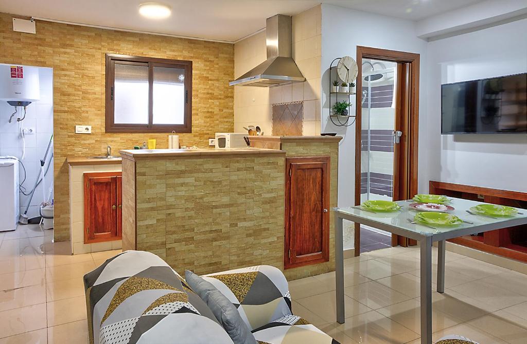 cocina con mesa y TV en una habitación en Apartamento Muralla, en Sevilla