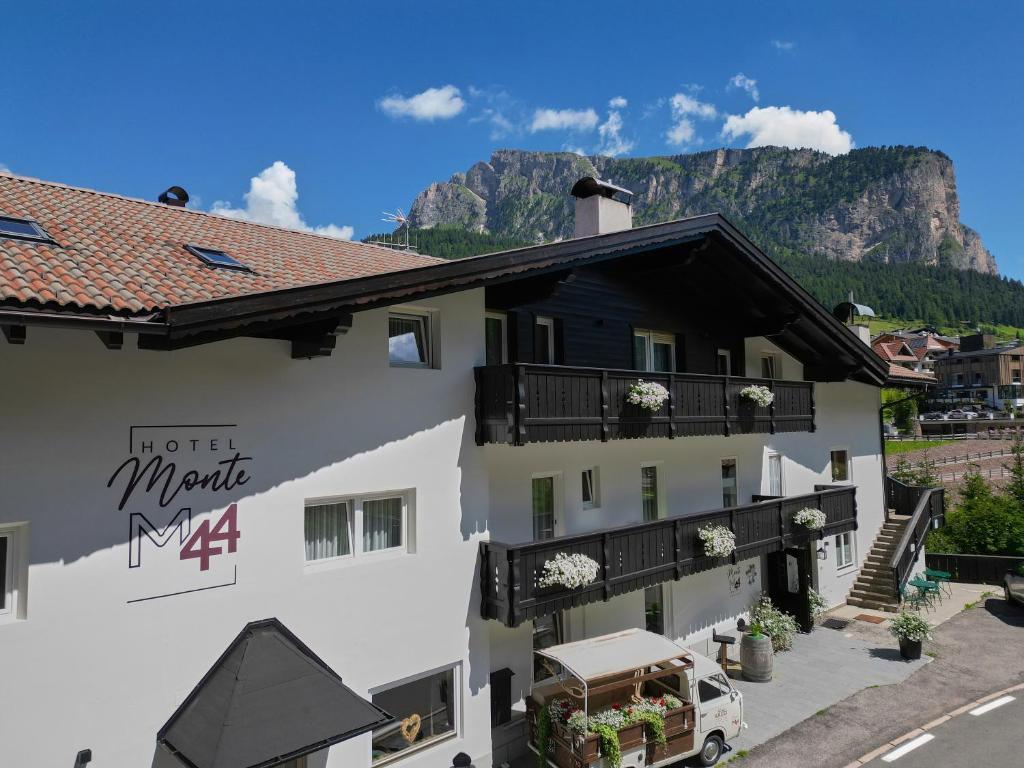 een hotel met een berg op de achtergrond bij Hotel Monte44 in Selva di Val Gardena