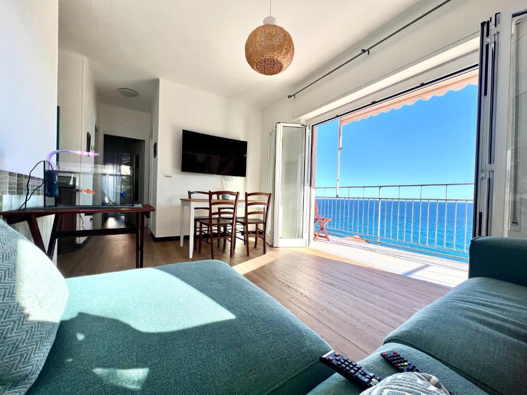 Una sala de estar con un sofá y vista al mar. en La casa alle Calandre, en Ventimiglia