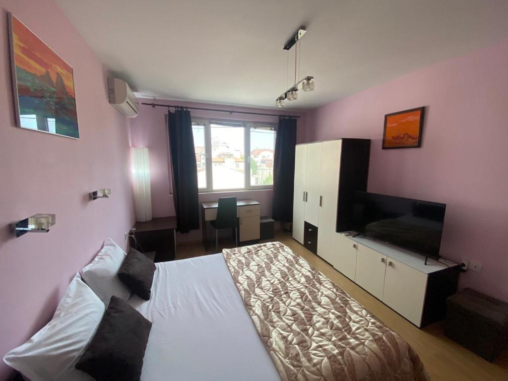- une chambre avec un lit et une télévision dans l'établissement Holidays apartment Bourgas, à Bourgas