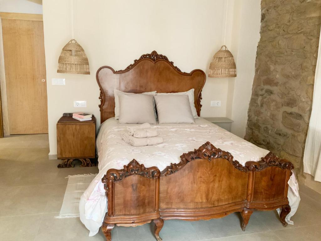 1 dormitorio con cama de madera y cabecero de madera en El Reposo de la Grulla, en Perales del Puerto