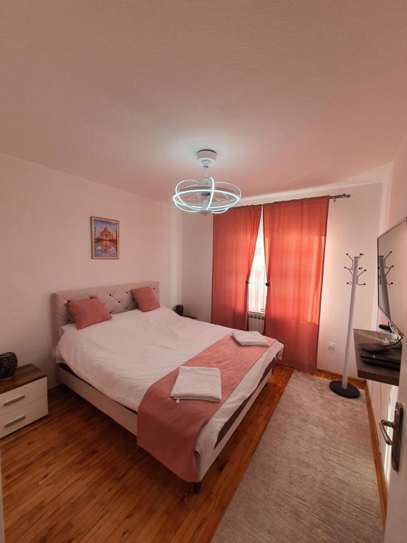 a bedroom with a large bed and a chandelier at Sarajevo Central View Apartment in Sarajevo