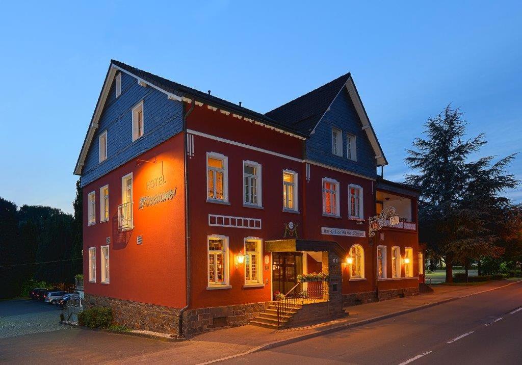 a large red building on the side of a street at Hotel Stremme in Gummersbach