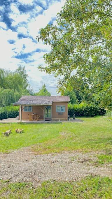 una pequeña casa en un campo con un árbol en Petite maison dans la prairie, en Marmeaux