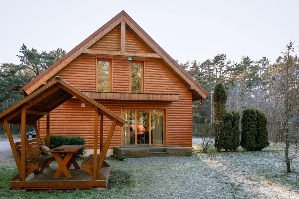 a small wooden cabin with a large window at BASH Village House in Ventspils