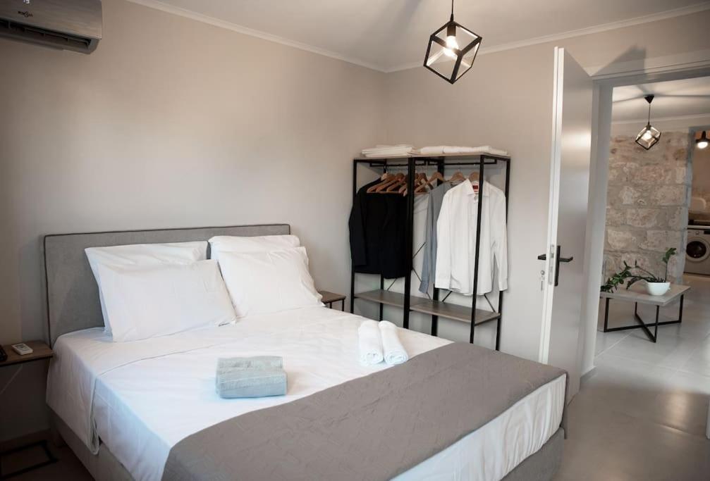 a bedroom with a bed and a rack of clothes at Myra city House in Chania Town