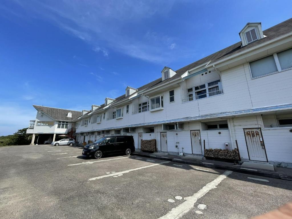 une voiture garée dans un parking en face d'un bâtiment dans l'établissement Umi no Gohanya Noramare - Vacation STAY 18208v, à Masuda