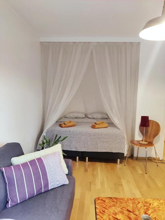a bedroom with a bed and a couch at Möysä beach apartment in Lahti